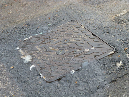 Sewage forces its way out of a manhole cover in Holloway Lane